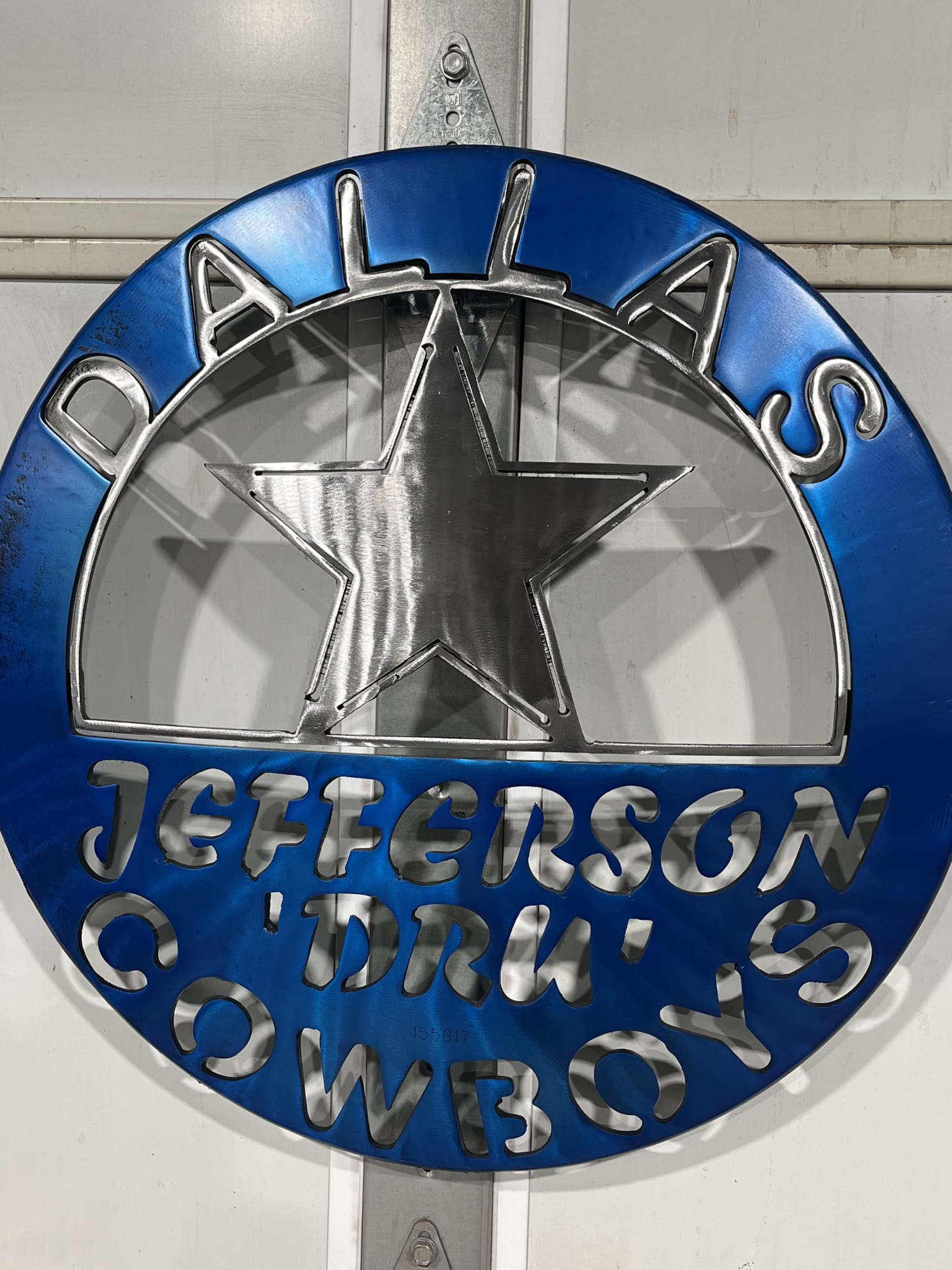 Metal sign with the Dallas Cowboys logo in the center.